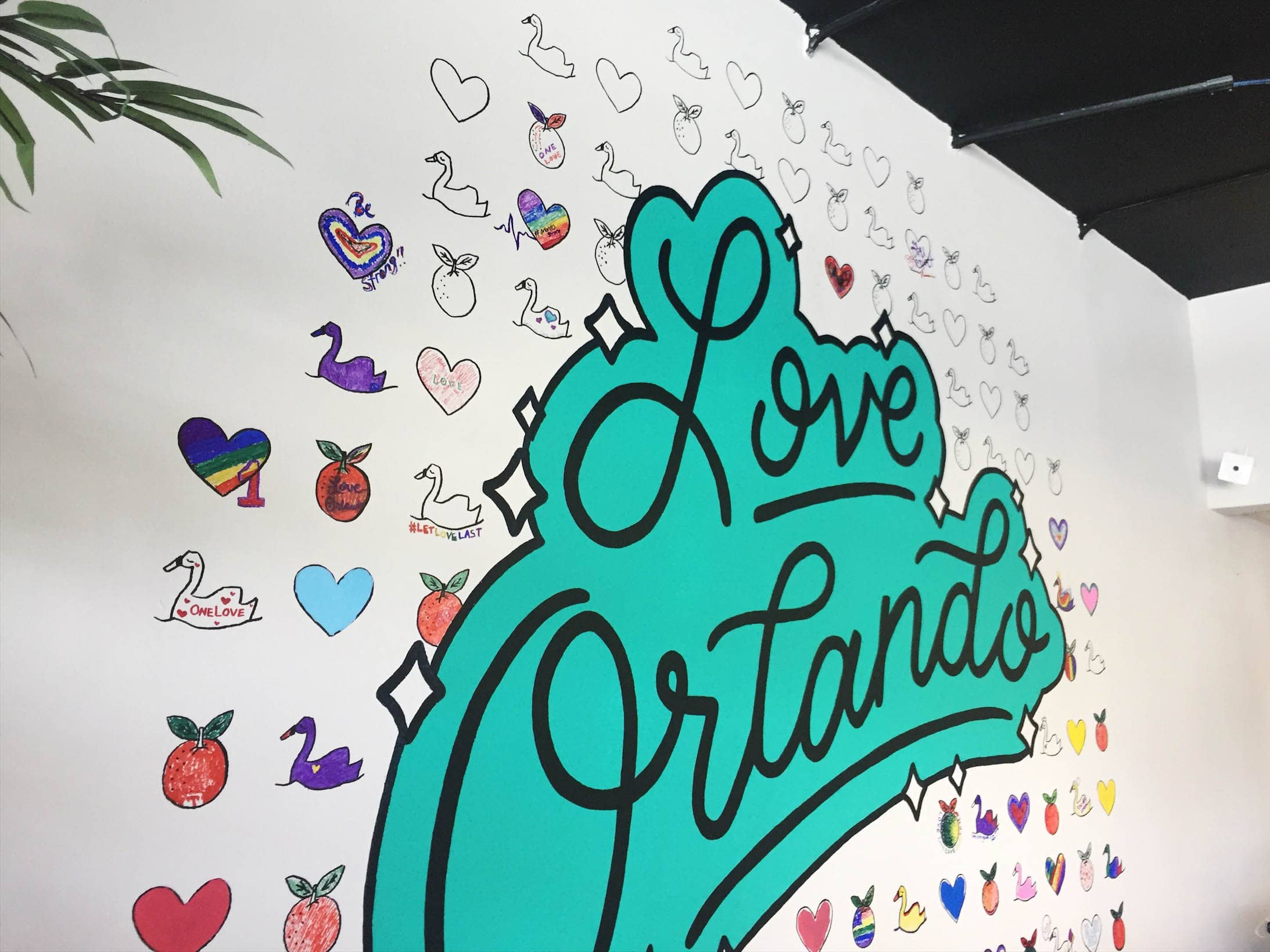 Love Orlando hand lettering by Hillery Powers mural at Orlando Shirts black teal turquoise blue rainbow